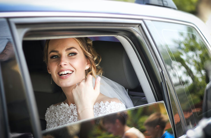 ウェディング姿で車に乗る女性の写真